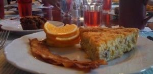 plate with bacon, quiche and sliced oranges