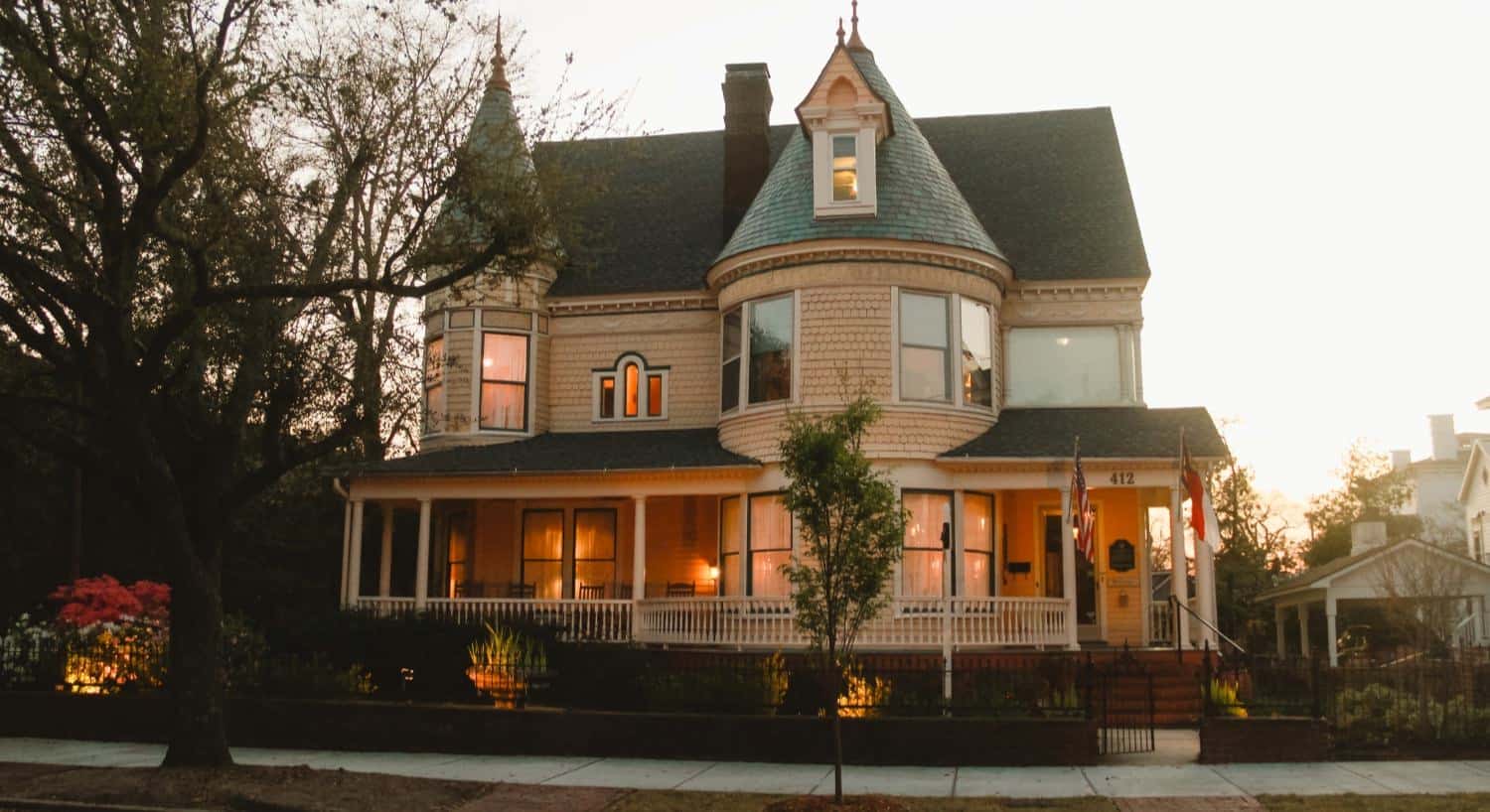 Exterior view of Victorian property with large front porch close to dusk